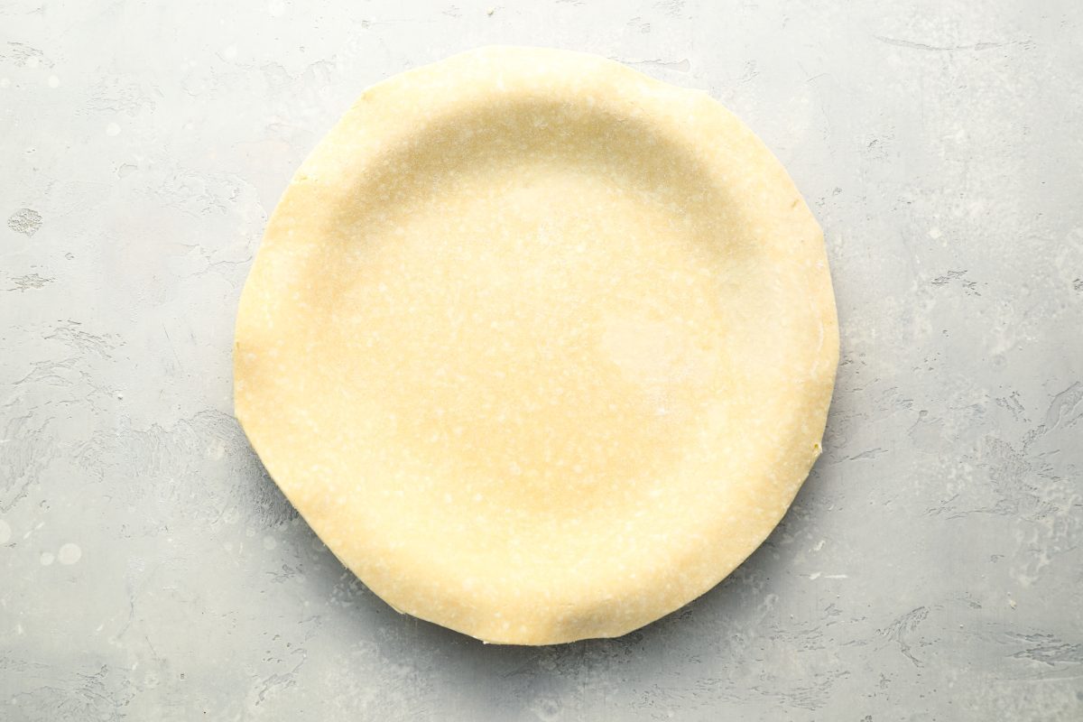 dough pressed into pie pan with edges trimmed