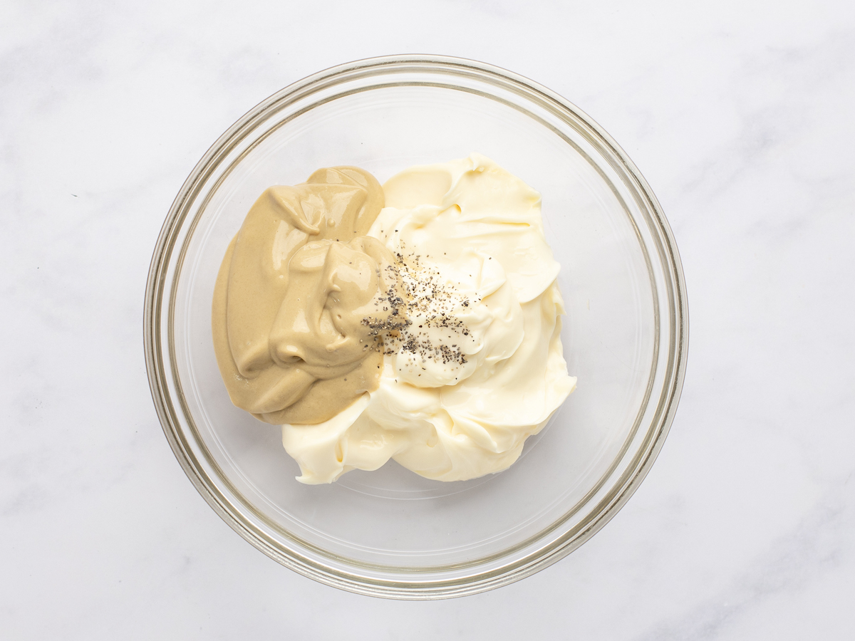 mayonnaise, mustard, and pepper in piles in small glass bowl