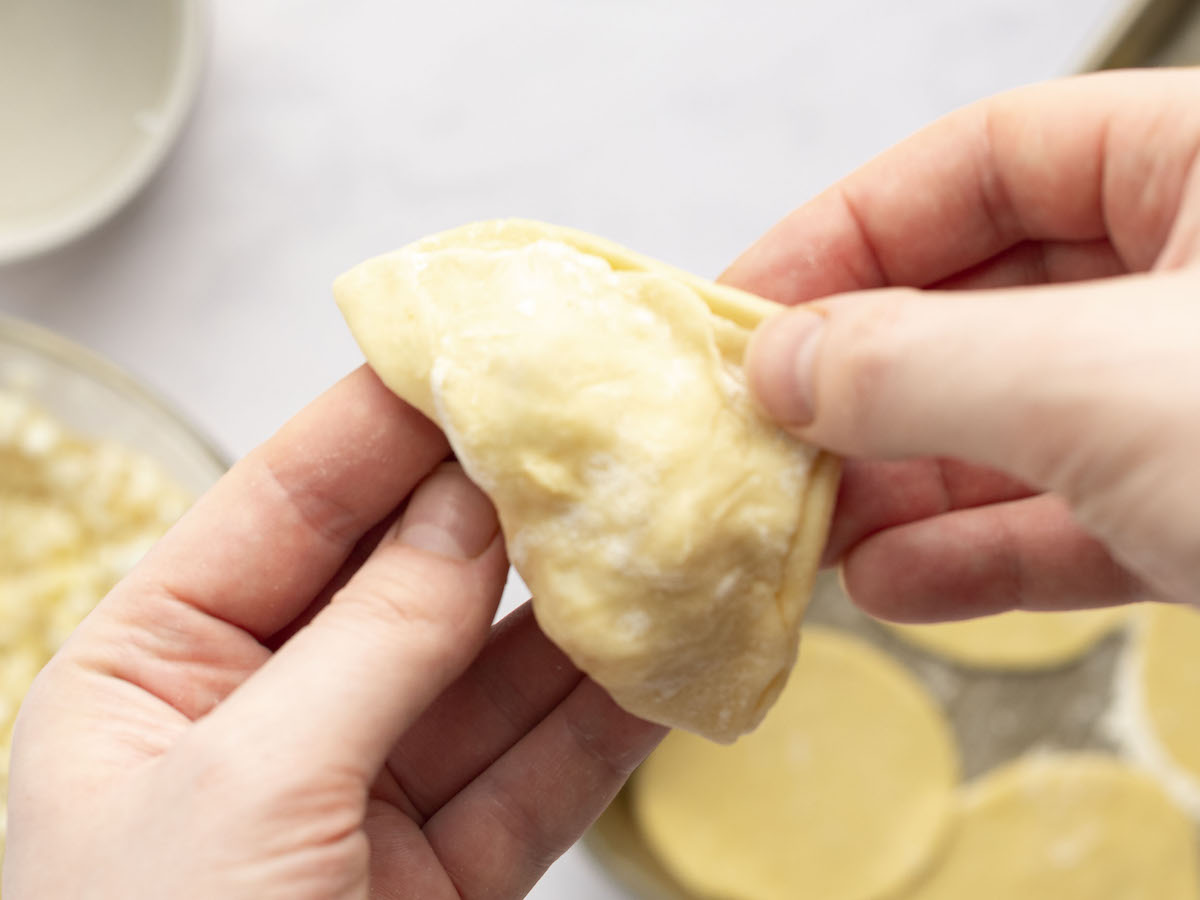 pinching dough along entire edge of pierogi to seal filling in