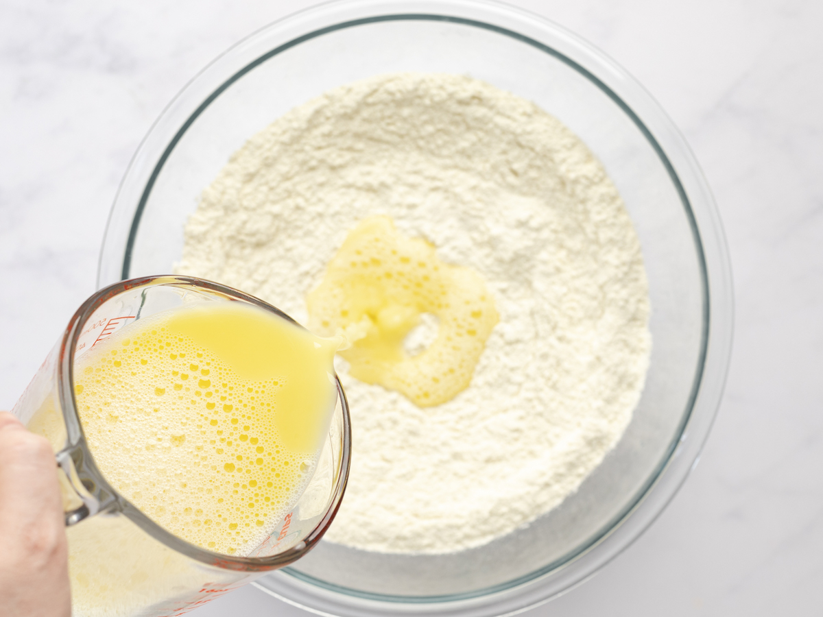 adding egg/water mixture to bowl containing flour and salt