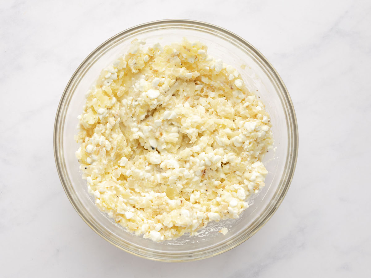 sauteed onions, mashed potatoes, cottage cheese, salt, and pepper combined in large glass bowl