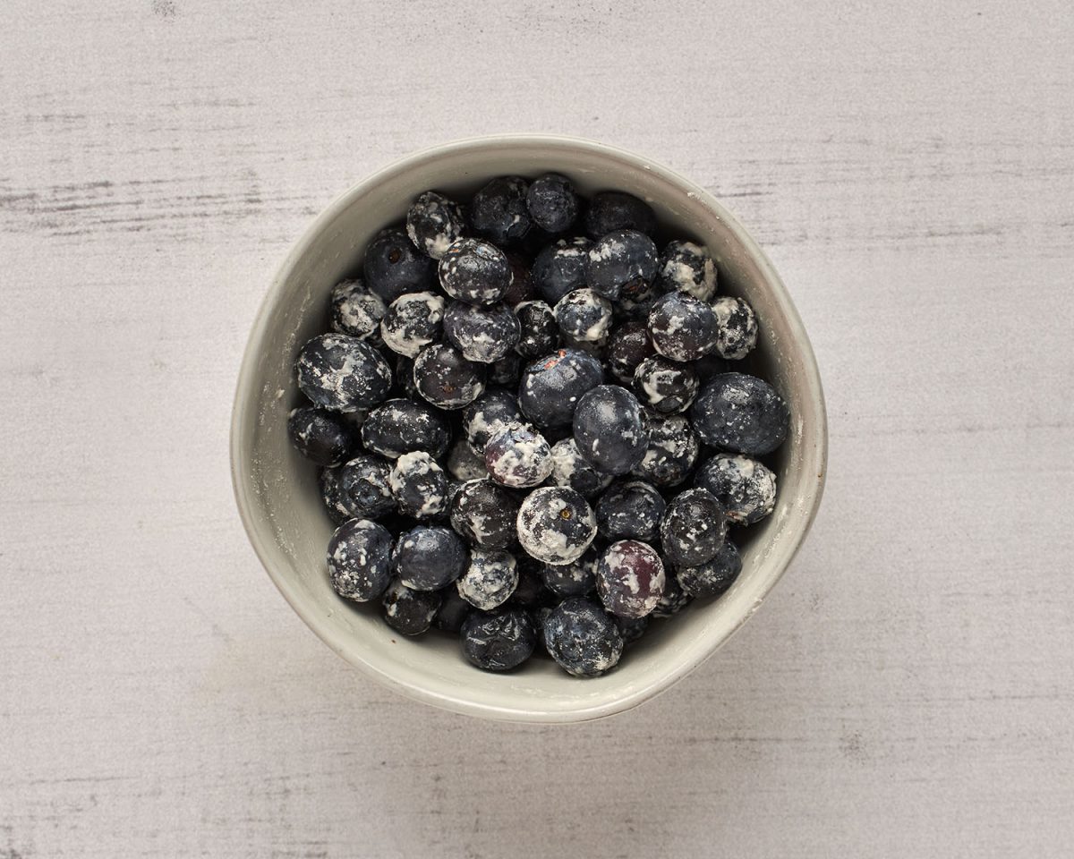 blueberries tossed in flour in small white bowl