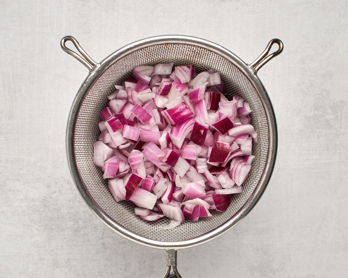 fine mesh sieve with red onion drained of water