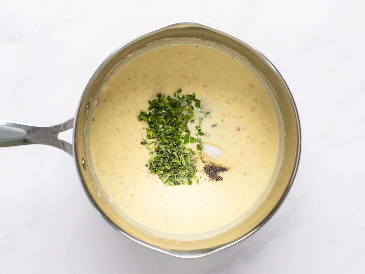 adding herbs and seasoning to beurre blanc