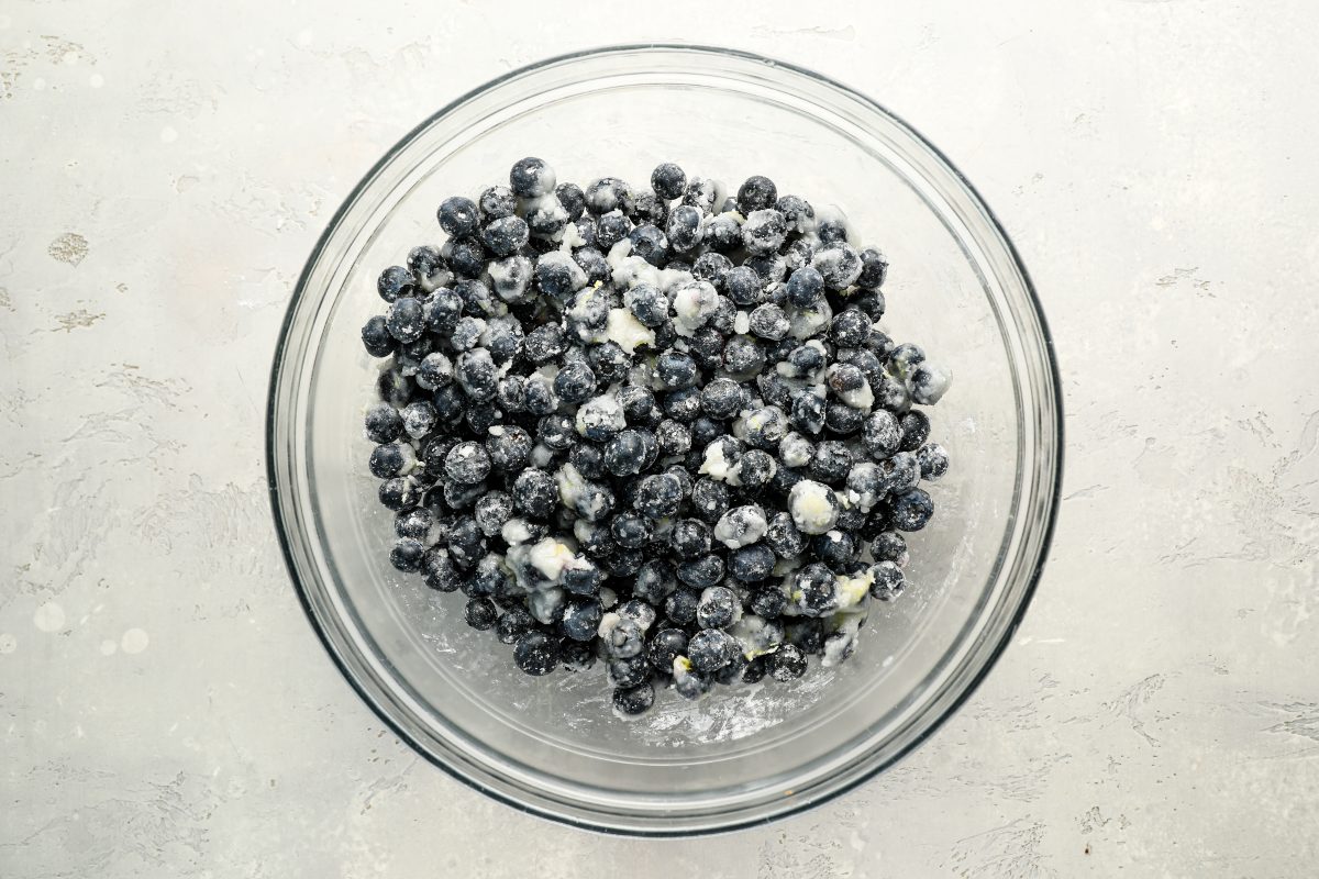 large bowl with blueberries tossed with lemon zest, lemon juice, sugar, salt, and tapioca flour