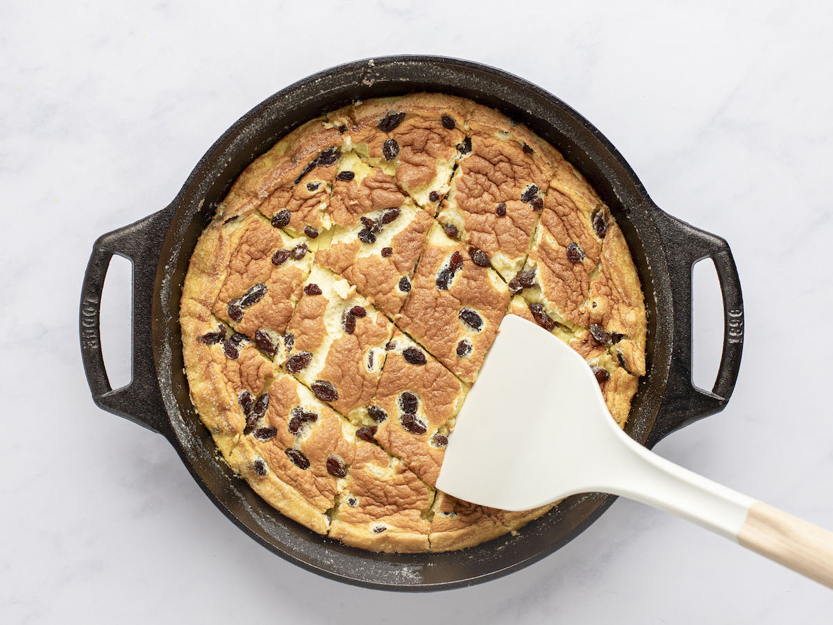 spatula breaking pieces of baked  kaiserschmarrn  into pieces