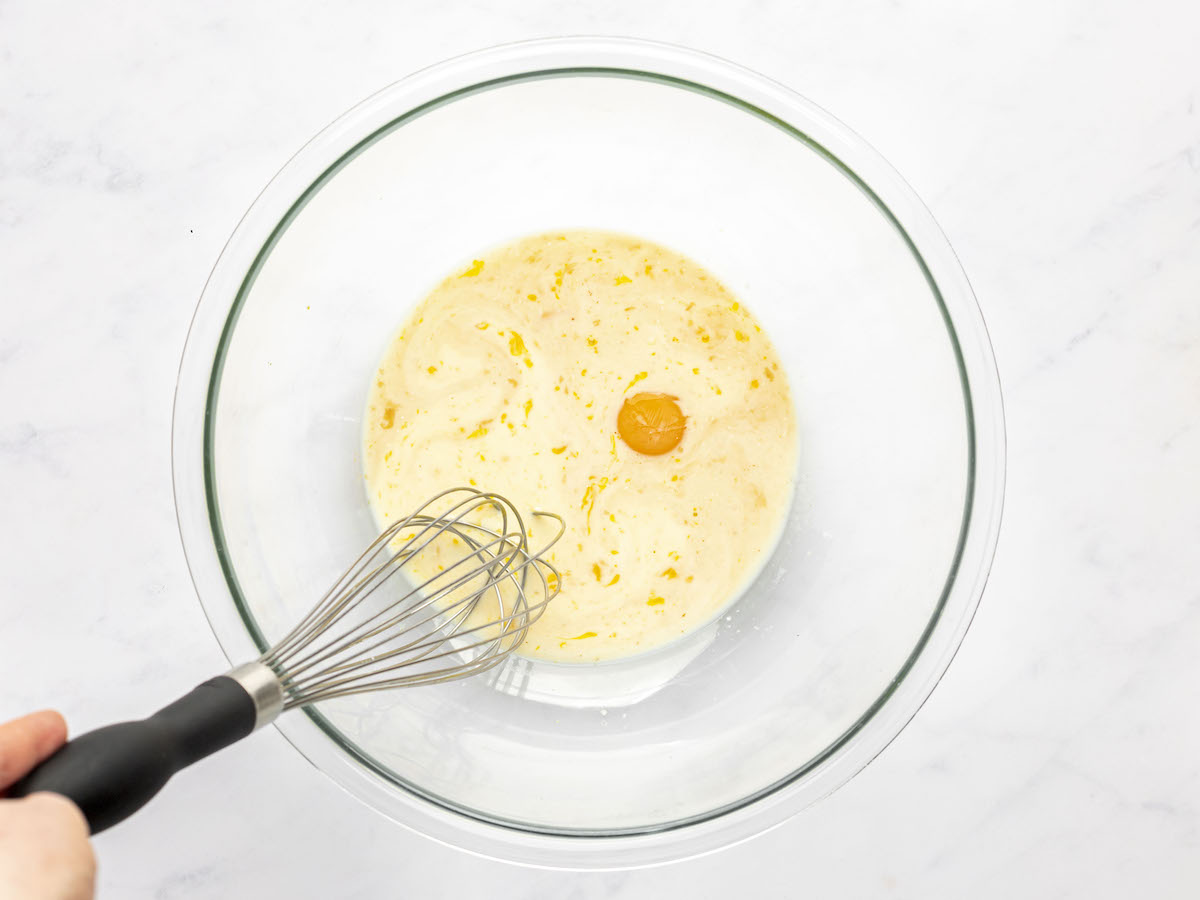 large bowl with egg yolks, milk, vanilla, and 1 tablespoon rum