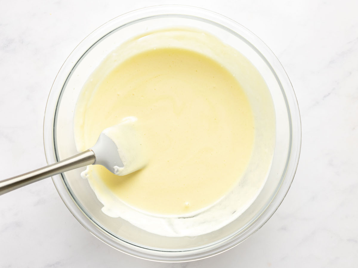 spatula combining whipped egg whites with egg yolk mixture in large bowl