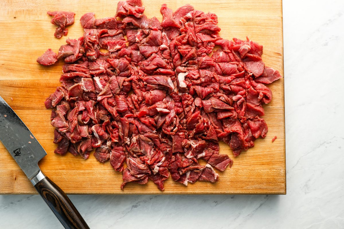 sirloin steak coarsely chopped on wood cutting board