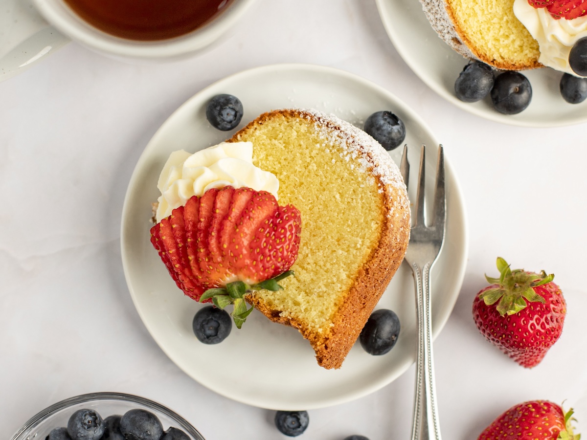 sliced pound cake with whipped cream and berries