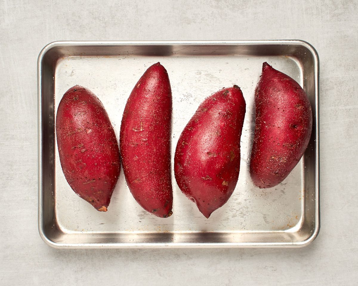 poked sweet potatoes on baking sheet