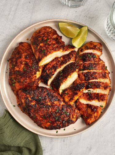 blackened chicken sliced on platter with green napkin