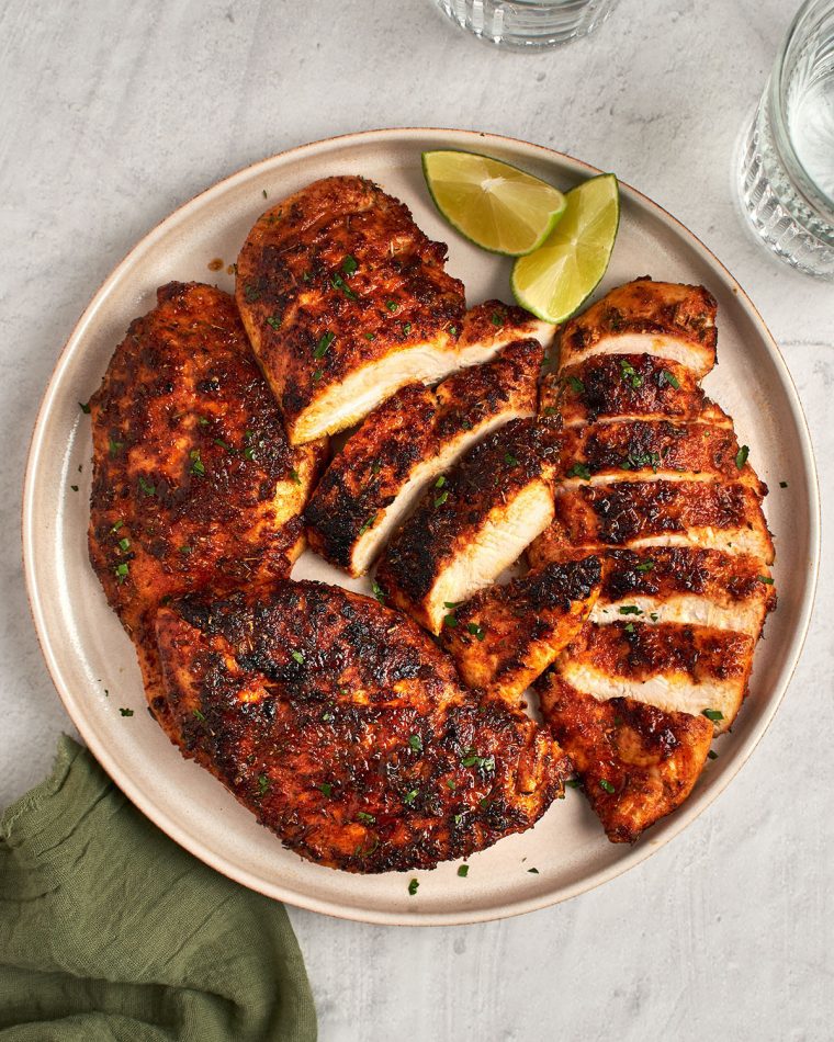 blackened chicken sliced on platter with green napkin