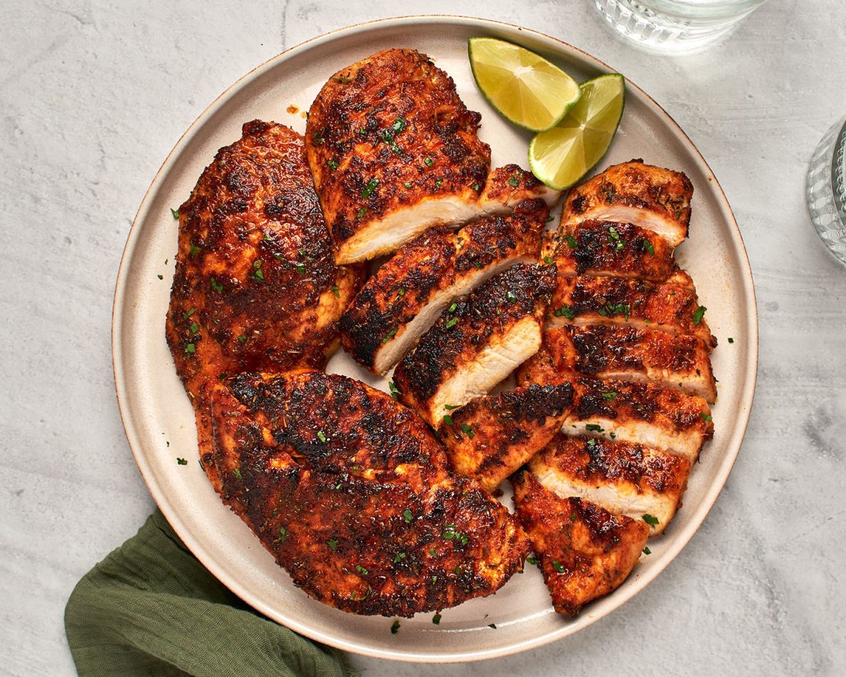 blackened chicken sliced on platter with green napkin