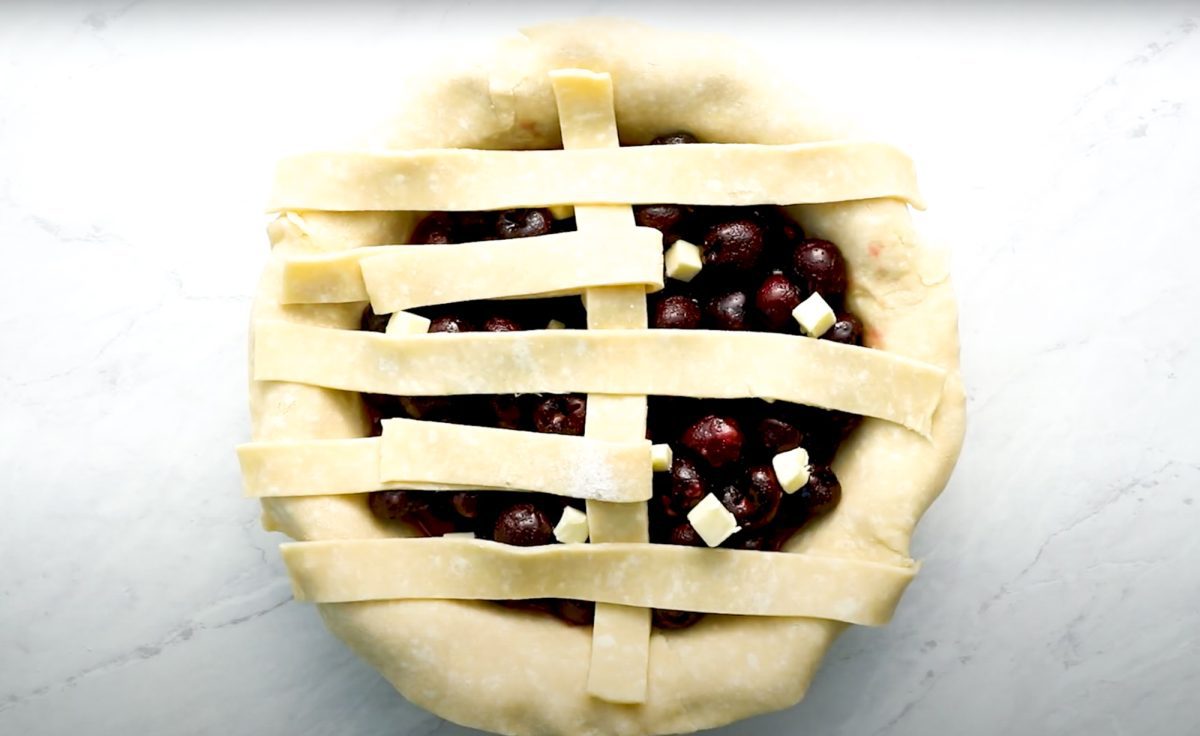 process of creating lattice crust for cherry pie