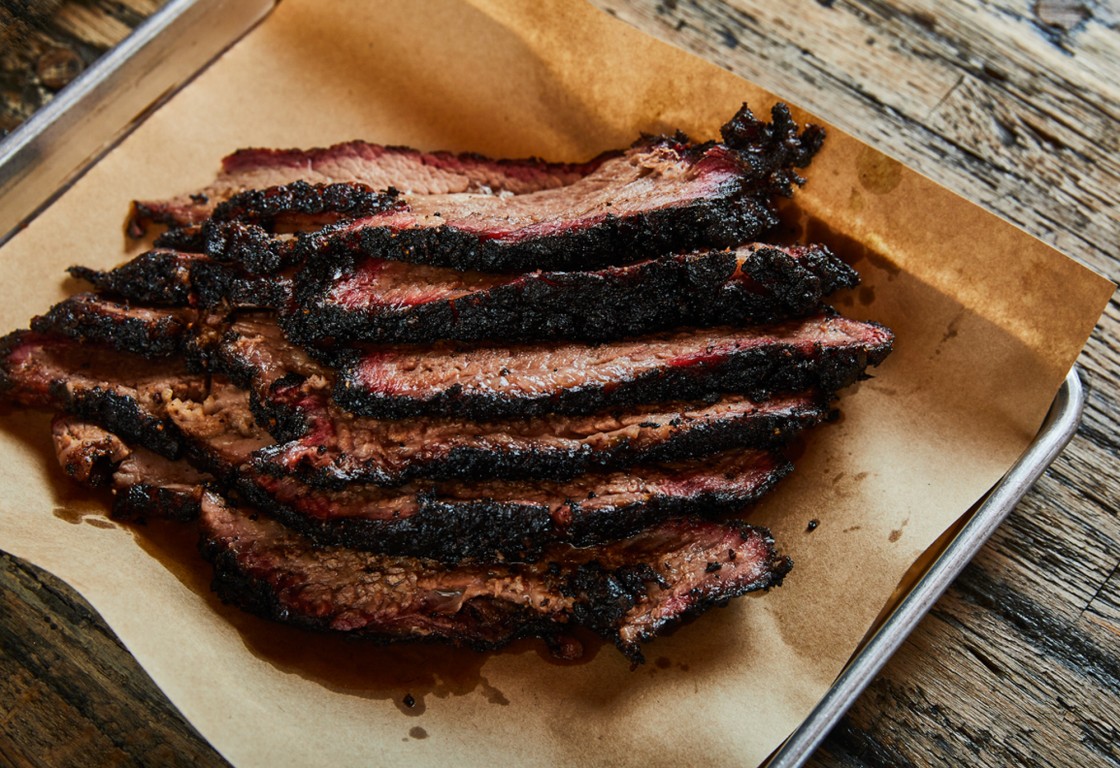 smoked brisket on parchment paper lined baking sheet