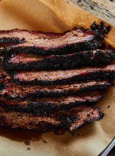 smoked brisket on parchment paper lined baking sheet