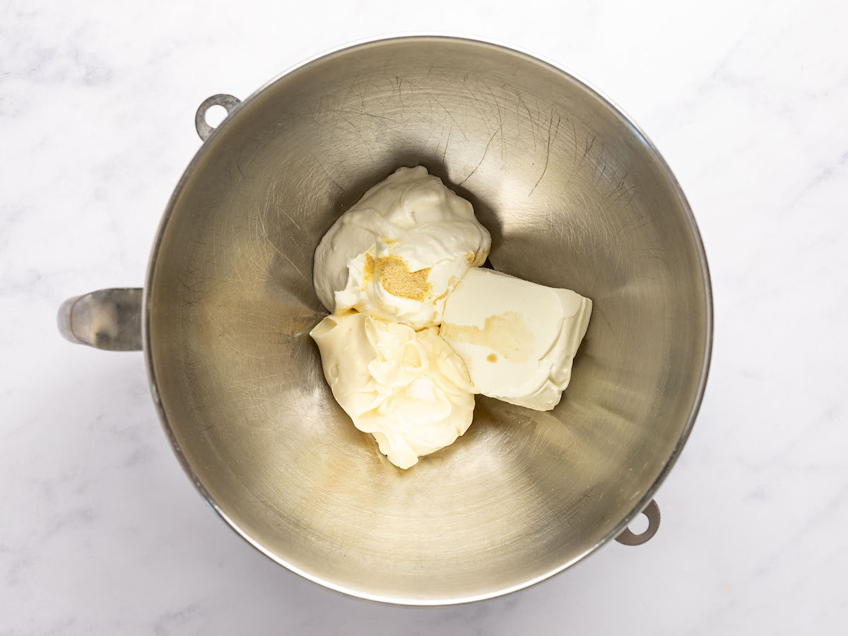 electric mixing bowl with cream cheese, sour cream, mayonnaise, Worcestershire sauce, garlic powder, and sugar