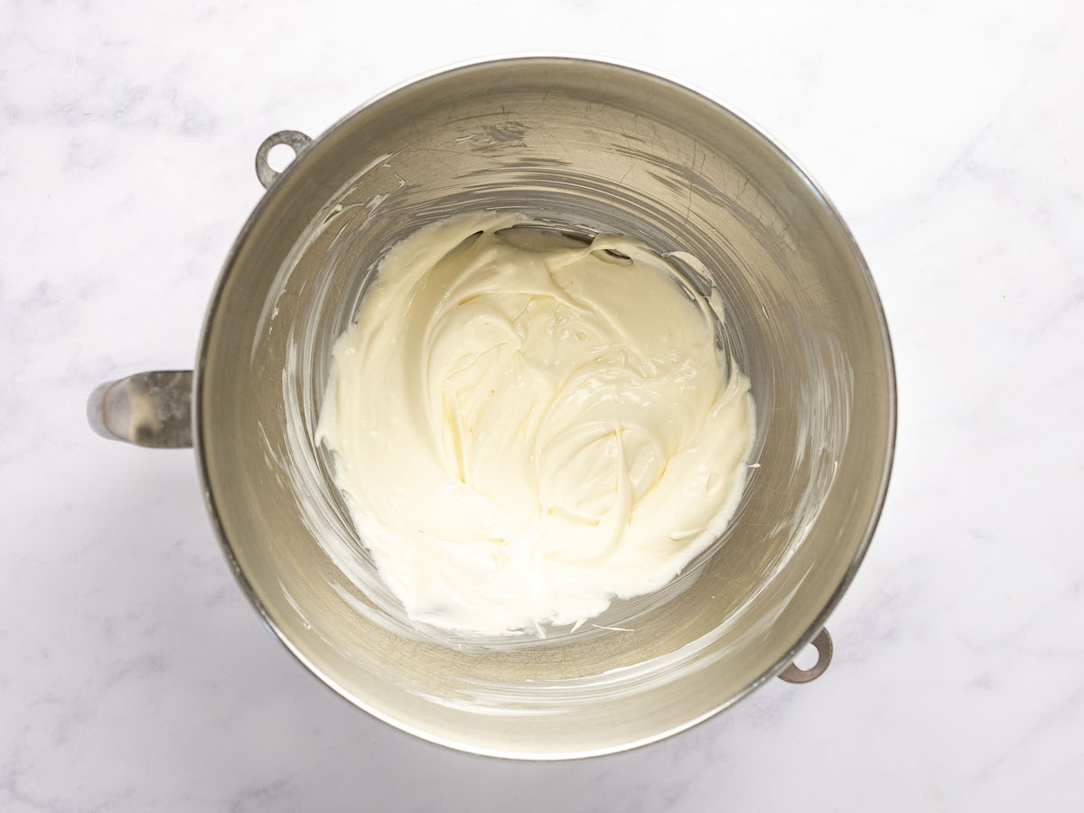 electric mixing bowl with cream cheese, sour cream, mayonnaise, Worcestershire sauce, garlic powder, and sugar combined together