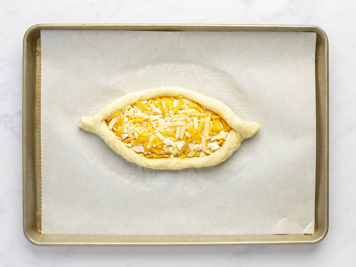 cheese-filled dough with edges folded and twisted to resemble the shape of a boat