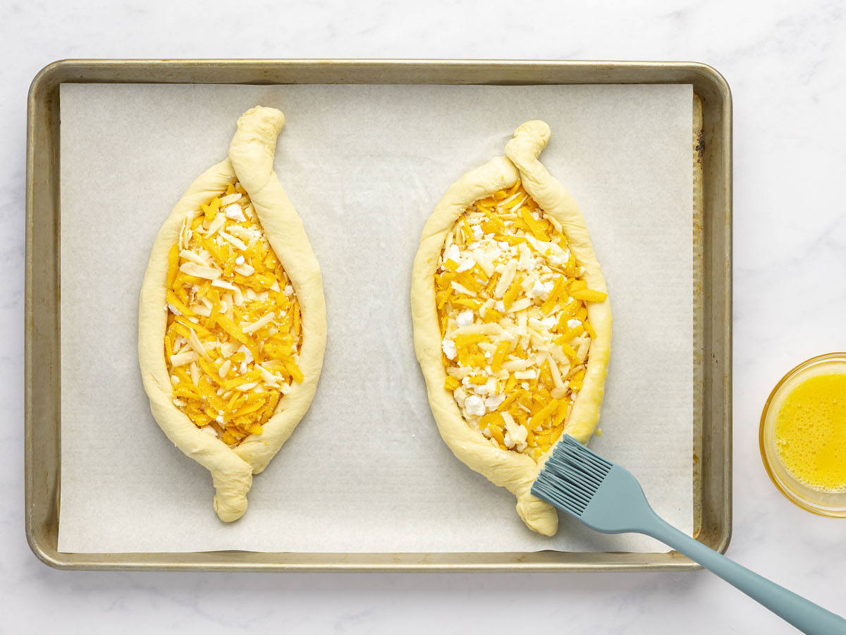 brushing exposed edges of dough with egg wash