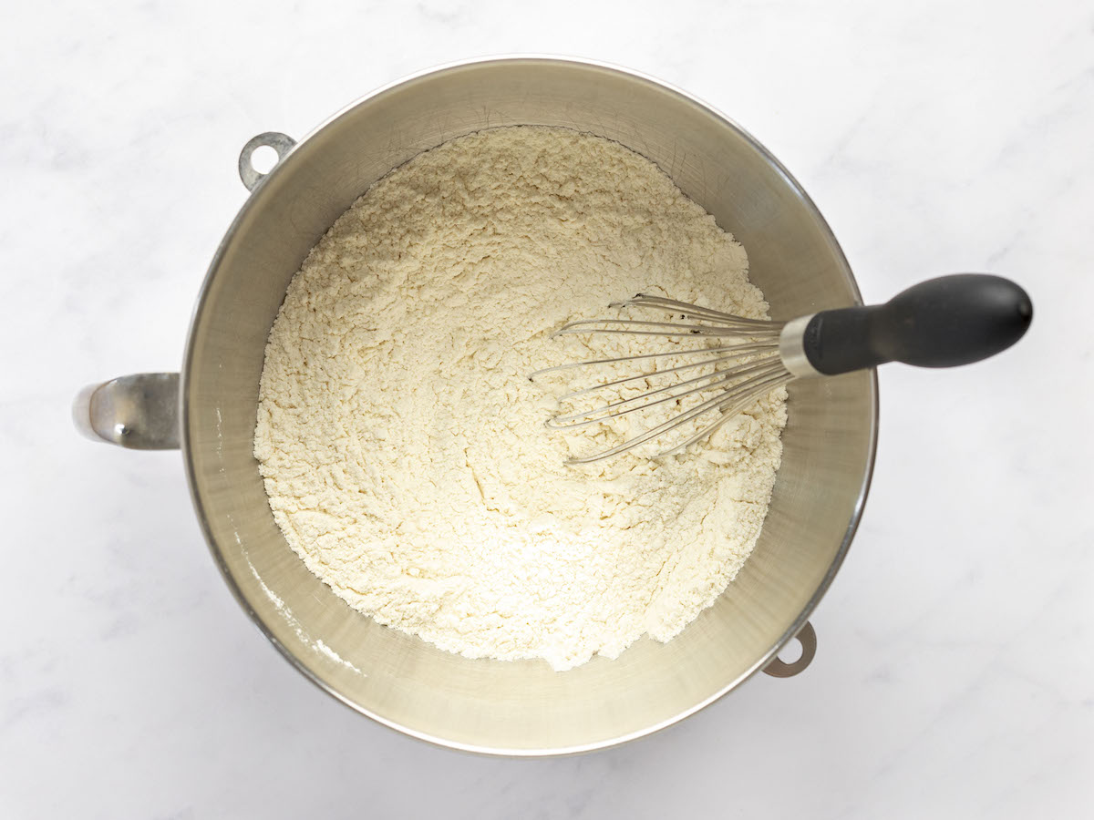 whisk combining flour, yeast, sugar, and salt in large bowl