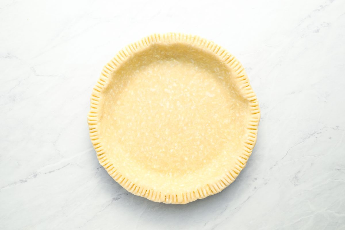 crust in pie pan with edges trimmed and crimped