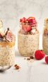 4 jars of overnight oats topped with a variety of fresh fruit and granola