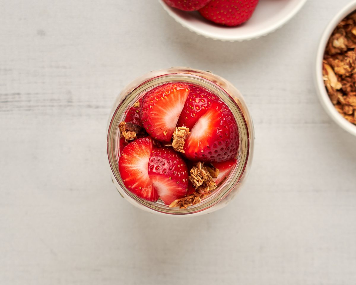 small jar with overnight oats topped with fresh strawberries