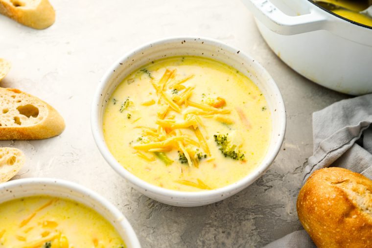 bowls of broccoli cheddar soup topped with cheese