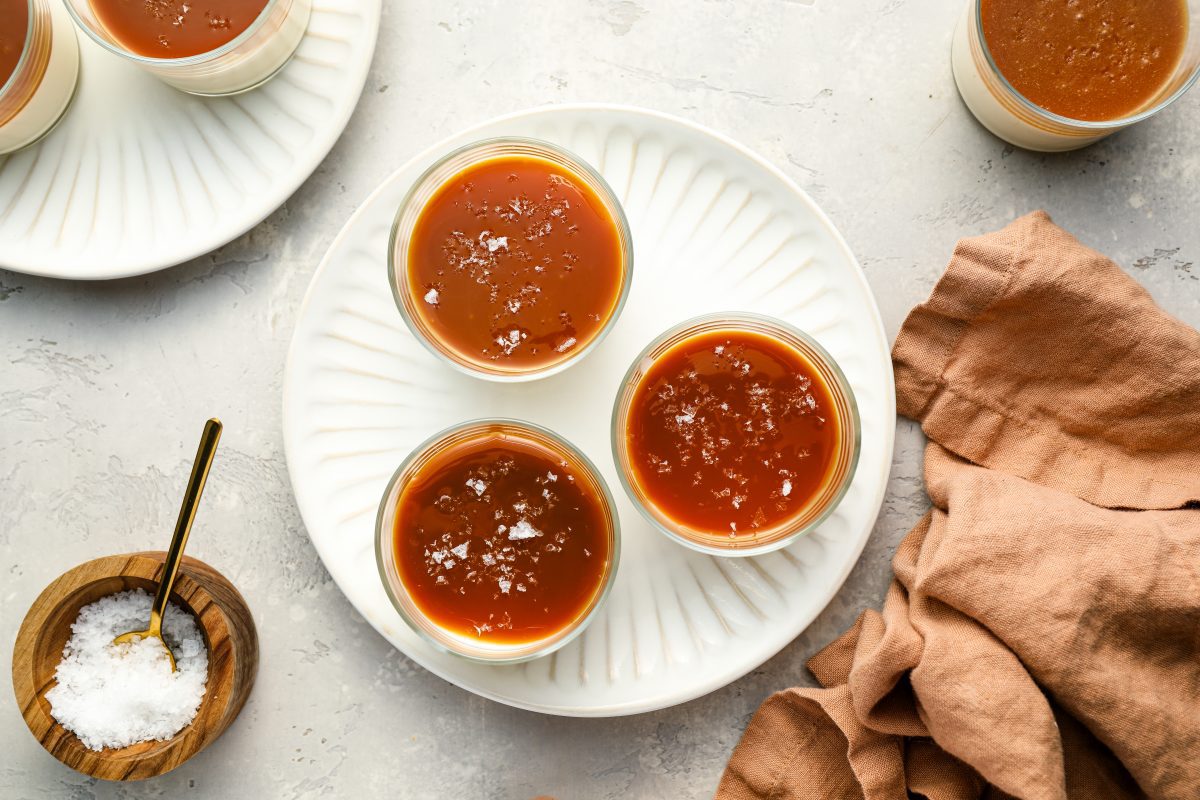 3 cups of caramel covered panna cotta on white plate 