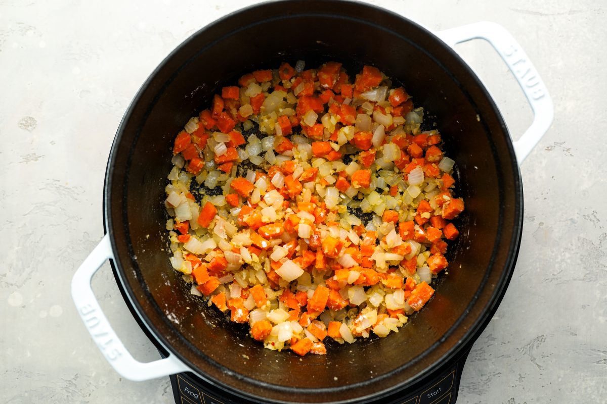 dutch oven with flour mixed into cooked garlic, onion and carrots 