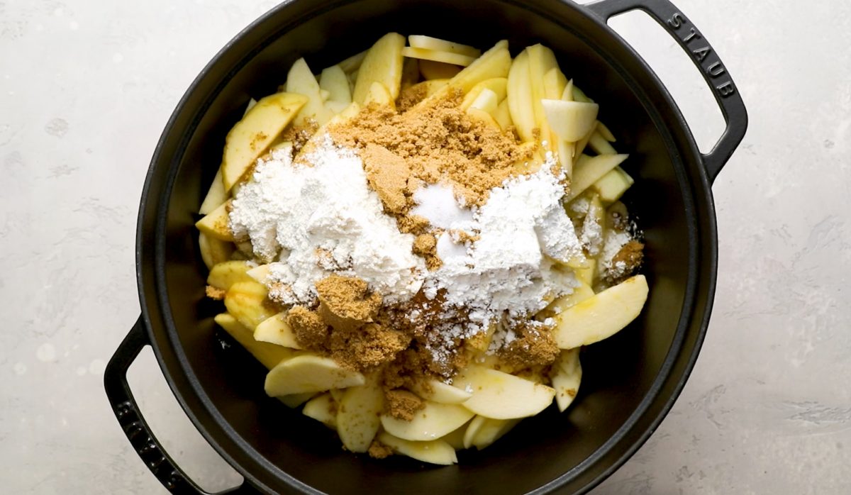 sliced apples in Dutch oven with brown sugar, cornstarch, flour, cinnamon and salt