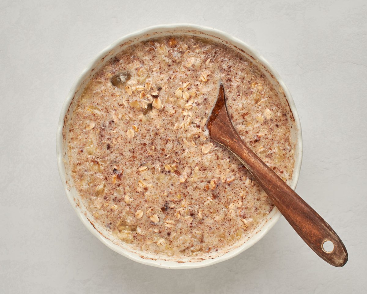 baked oatmeal mixture in bowl with wooden spoon