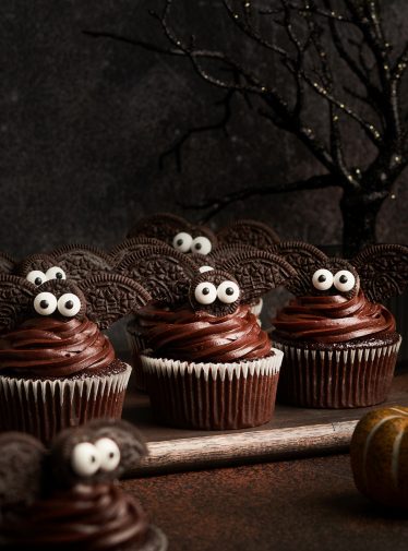 adorable bat cupcakes on cutting board with spooky tree