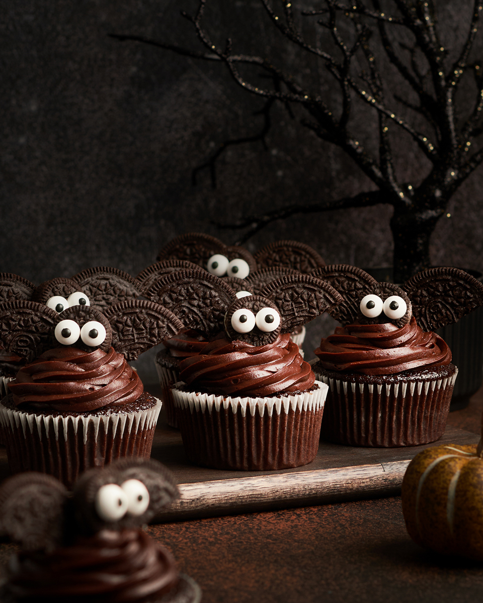 adorable bat cupcakes on cutting board with spooky tree