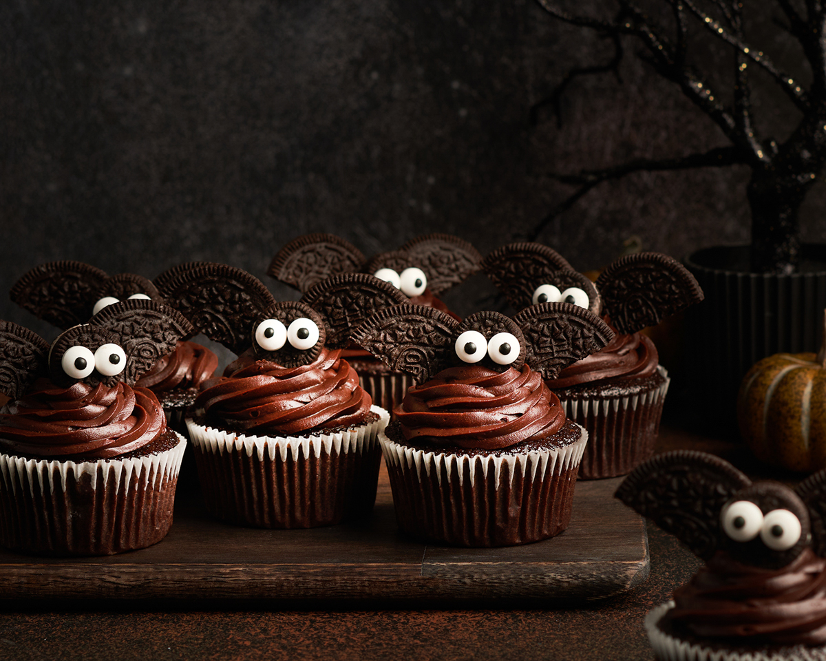 adorable bat cupcakes on cutting board with spooky tree