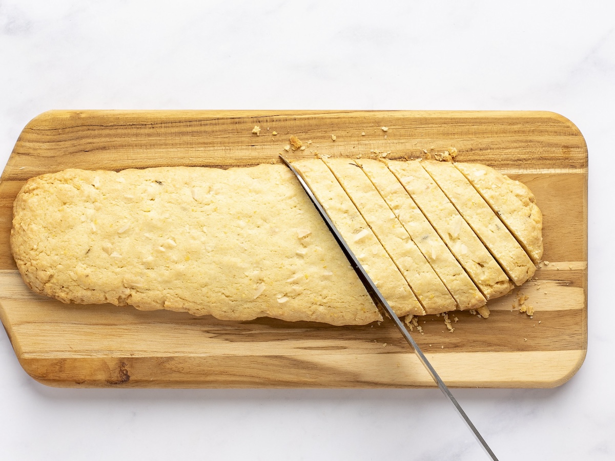 Slicing the biscotti on wooden cutting board.