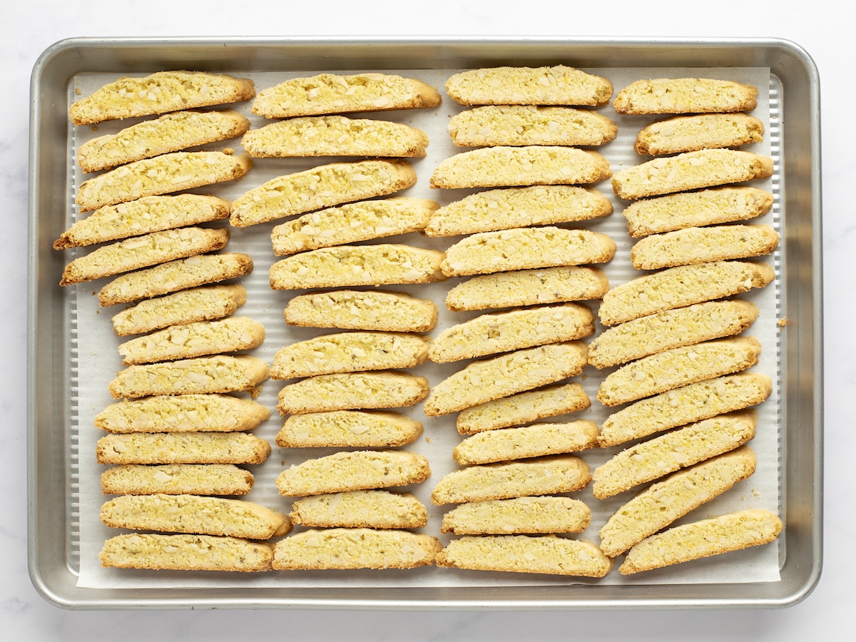 Sliced biscotti arranged on baking sheet.