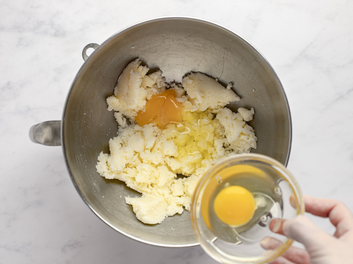 Adding eggs to creamed butter and sugar.