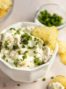 French onion dip in white bowl with potato chips