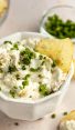 French onion dip in white bowl with potato chips