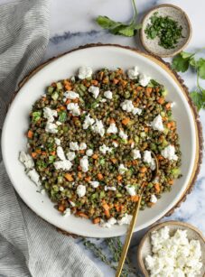 lentil salad in bowl with linen napkin and small bowls of parsley and goat cheese